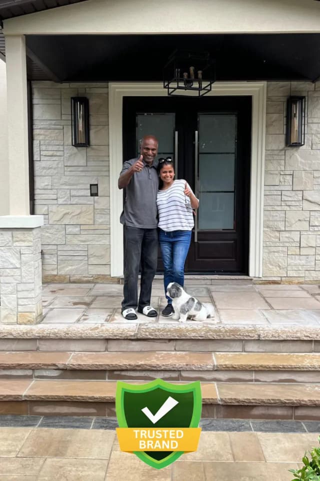 Smiling homeowner showcasing new stone patio